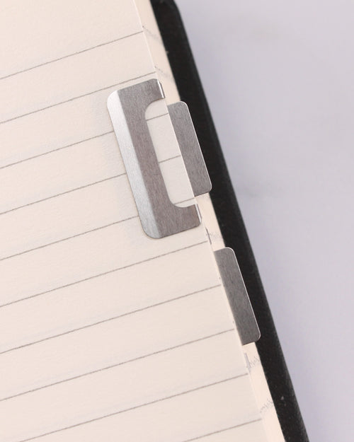 Clips índice Chiratto de Midori en metal, sujetos al borde de una libreta