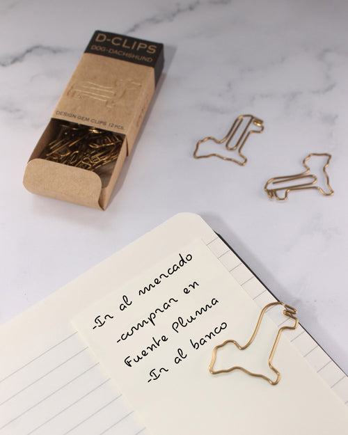 Caja mini de D-Clips de Midori con clips de perro sujeto a una libreta